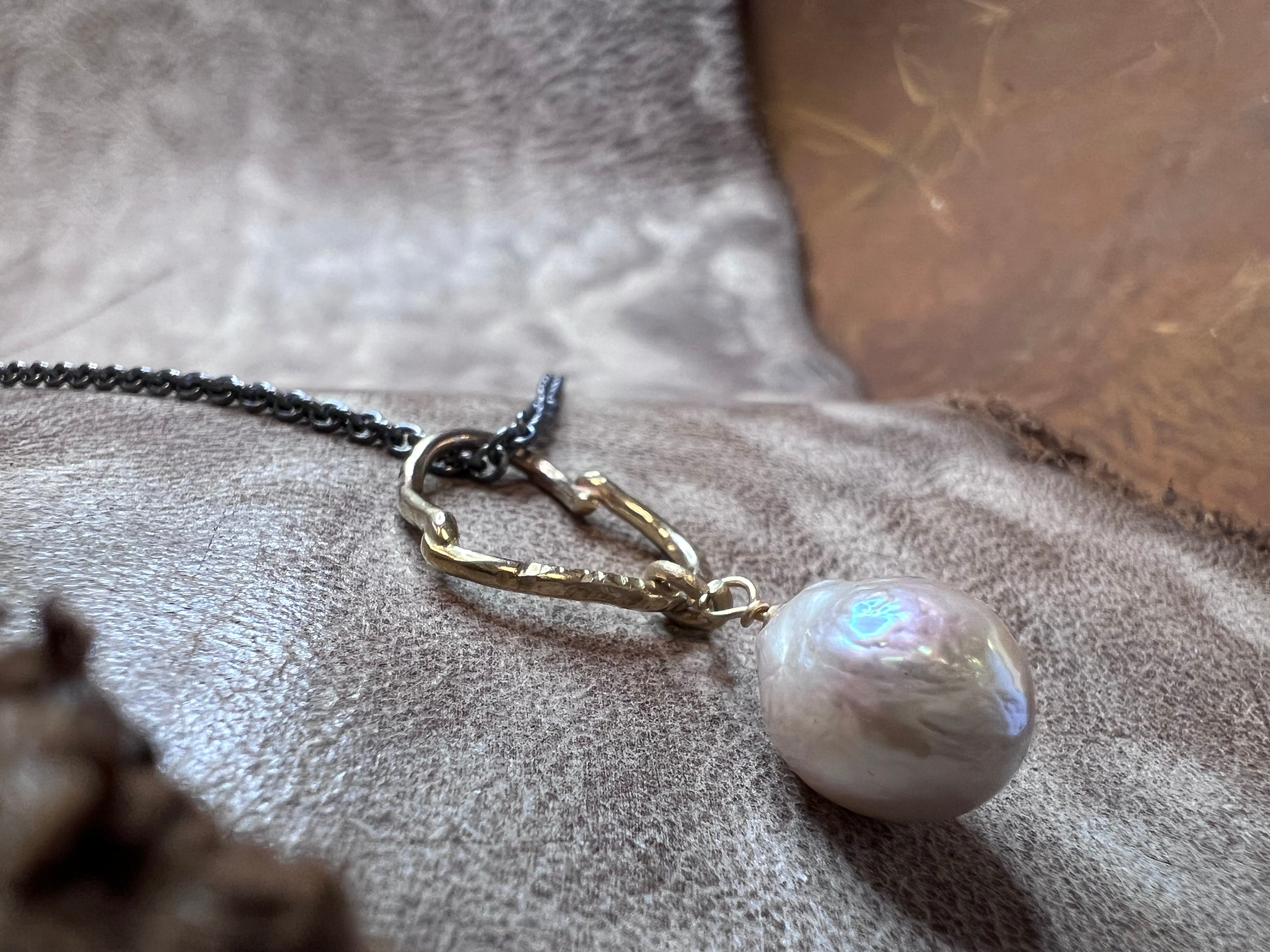 Et magiske hjerte i guld med perle i oxideret sølv kæde