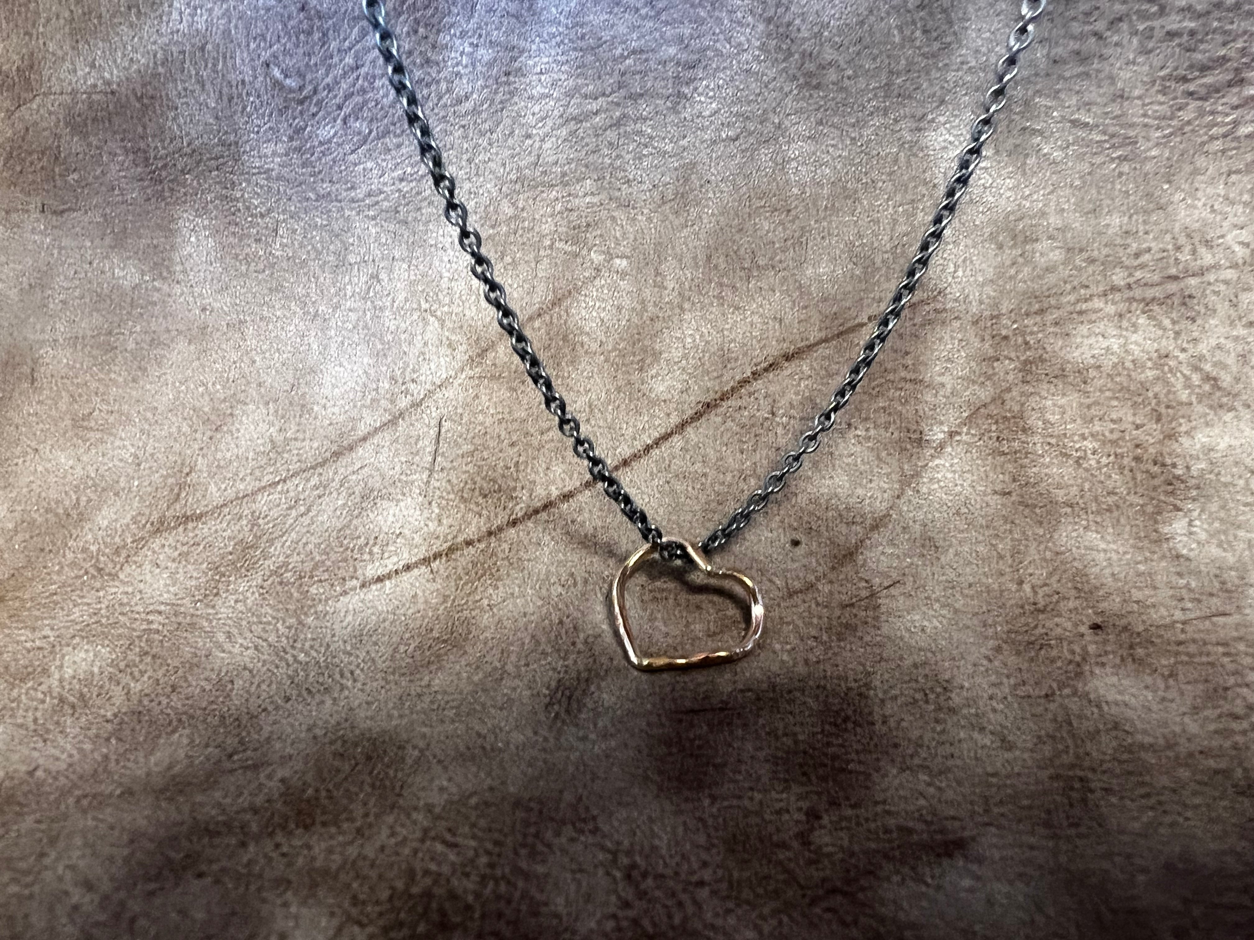 Et magiske hjerte i guld med oxideret sølv kæde